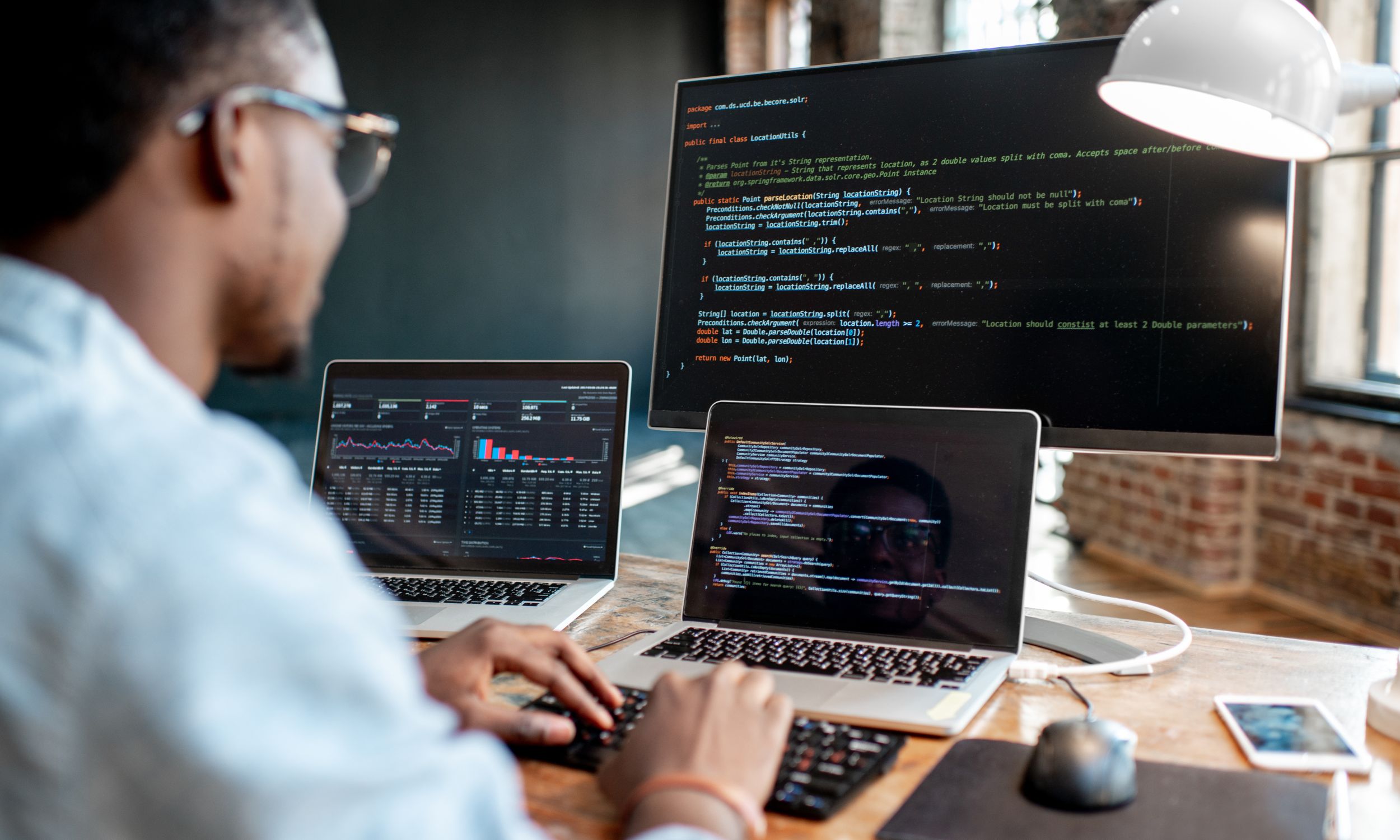 A student working on multiple computer screens with code and cybersecurity data, representing the hands-on cybersecurity training at St. Mary's Group of Institutions.